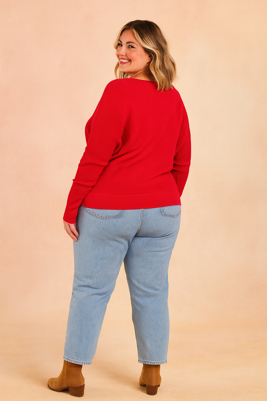 Vibrant red ribbed sweater paired with light blue straight-leg jeans and tan suede ankle boots.