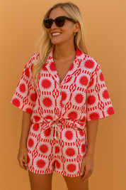 Playful co-ord set featuring a button-up shirt and drawstring shorts with a vibrant red and white geometric sunburst pattern.