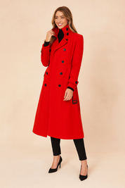 Bright red trench coat with stand-up collar, black button detailing, cuff straps, and belted sides, styled over black trousers and black pointed-toe heels.