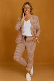 Casual tailored co-ord set with a red and white checkered blazer and matching drawstring trousers, styled with a classic white T-shirt and white sneakers for a smart yet sporty everyday look.