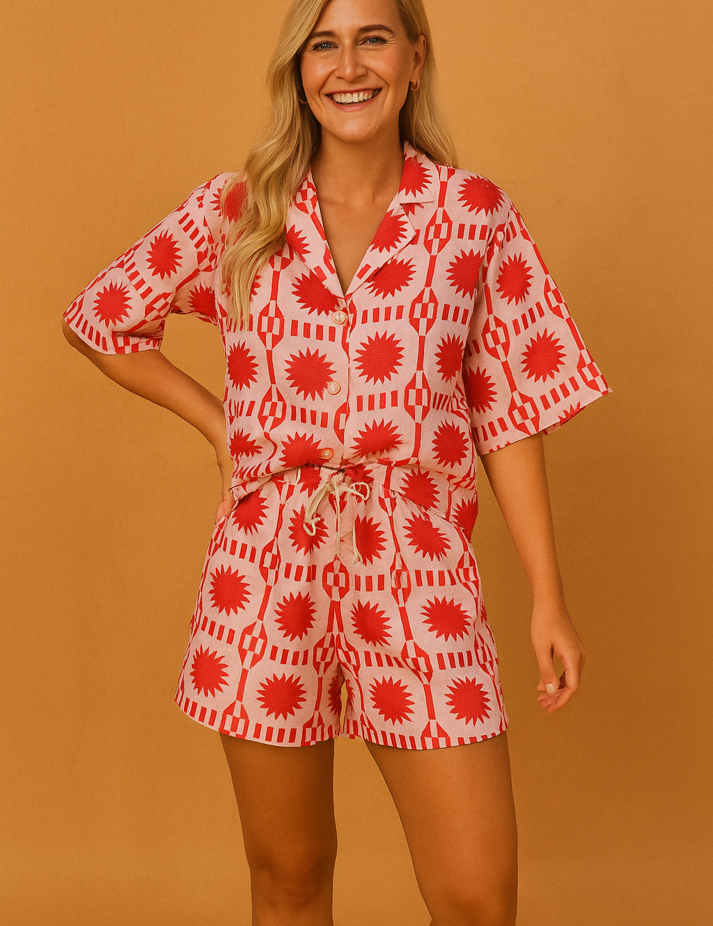 Red and white graphic print two-piece co-ord set featuring a relaxed button-up shirt with short sleeves and matching drawstring shorts, designed for a bold and playful summer look.