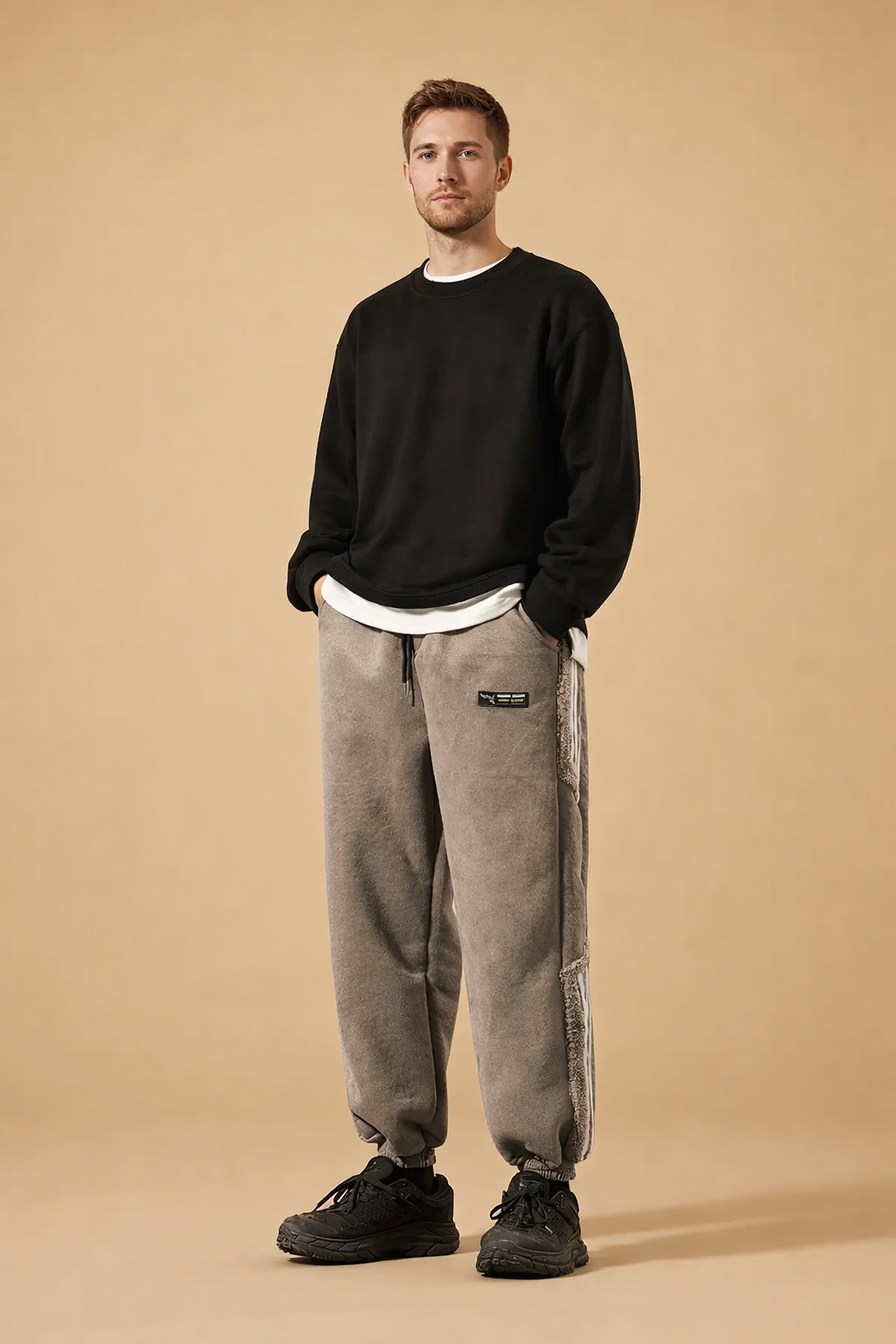 Relaxed-fit tapered jogger pants with elasticated cuffs, straight leg silhouette, soft textured finish, adjustable drawstring waist, and subtle side detailing paired with low-profile athletic footwear.
