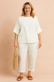 Minimalist white linen two-piece set featuring a loose-fit short-sleeve top and cropped straight-leg pants with subtle side button detail, offering a relaxed and breathable silhouette perfect for everyday comfort and effortless summer style.