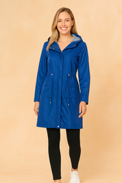 Royal blue hooded raincoat with striped inner lining, drawstring waist, front flap pockets, and buttoned cuffs, styled with a sleek full-length design.