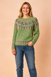 Sage green Fair Isle knit sweater with multicolored diamond pattern across yoke and cuffs, paired with classic blue jeans.