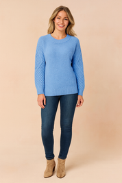 Sky blue textured knit sweater with patterned sleeves, paired with dark blue skinny jeans and taupe suede ankle boots.