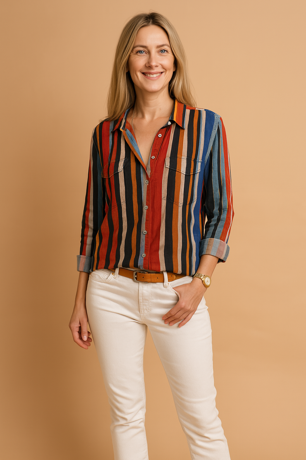 Women's long-sleeve button-up shirt with vertical stripes in red, black, orange, white, and navy, featuring dual chest pockets and rolled cuffs, paired with a tan belt and white jeans