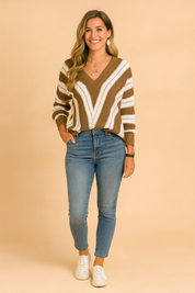 Brown and white striped V-neck knit sweater paired with blue jeans, styled for a cozy yet chic casual look.