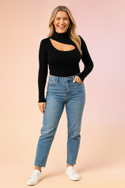Black ribbed turtleneck top with asymmetrical chest cutout, paired with light blue high-waisted straight-leg jeans and white sneakers.