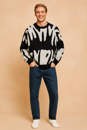 Black and white abstract-pattern knit sweater with a relaxed fit, crew neckline, and long sleeves, paired with classic blue jeans and white sneakers.