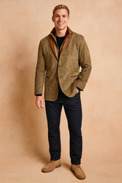 Brown suede blazer jacket with contrasting leather trim collar and pocket accents, button-up front, styled with a black sweater, dark jeans, and beige suede shoes.