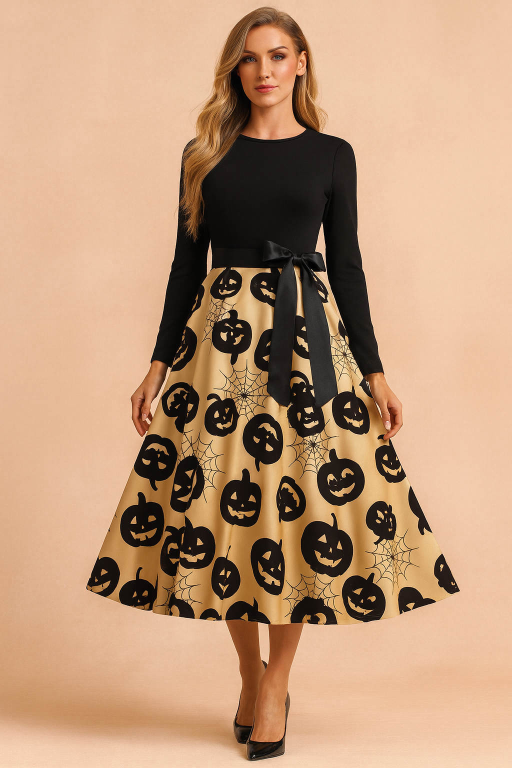 Sukienka halloweenowa retro z czarną górą z długim rękawem, satynową kokardą w talii i rozkloszowaną złotą spódnicą ozdobioną nadrukiem czarnych dyń i pajęczyn.