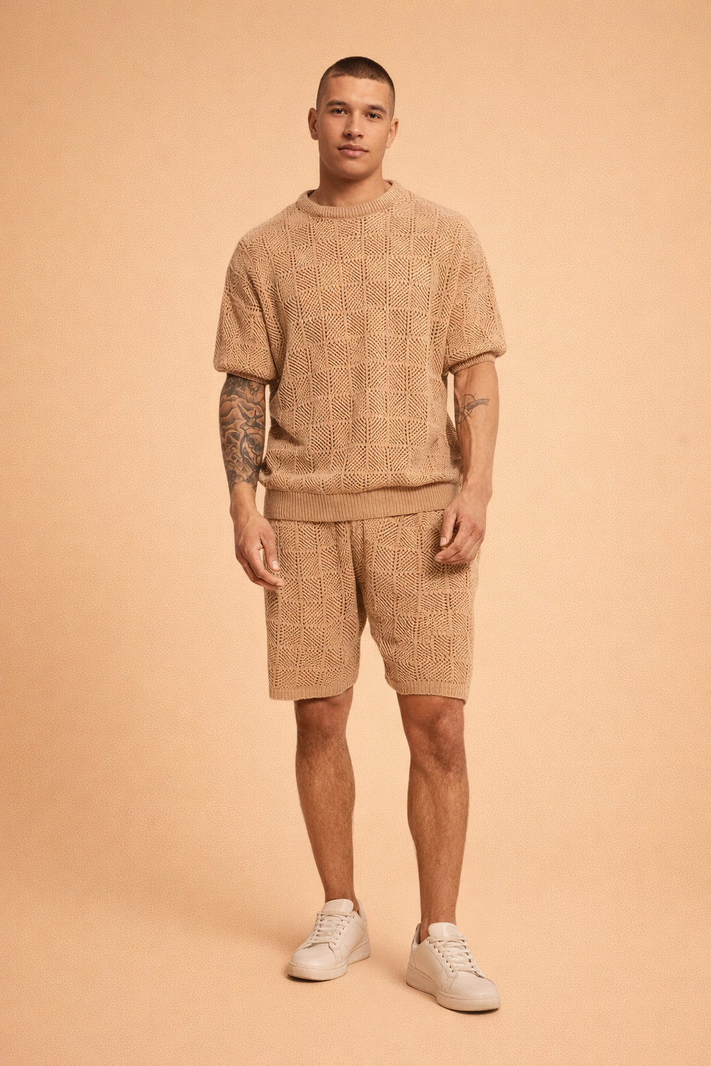 Men’s coordinated tan knit short-sleeve sweater and matching shorts set featuring a breathable geometric open-weave pattern, ribbed crew neckline, ribbed hem finish, relaxed tailored fit, and clean white low-profile sneakers for a refined summer casual look
