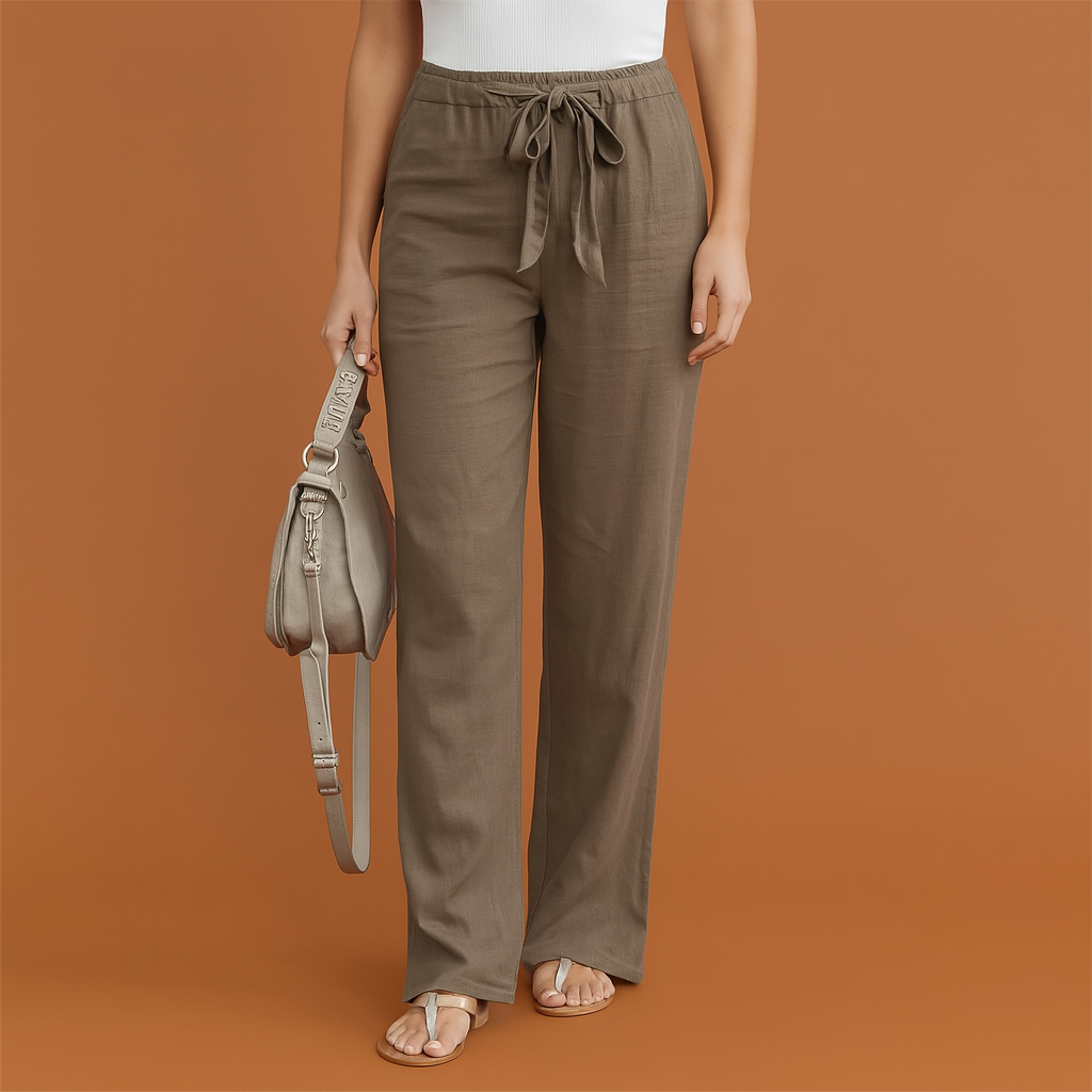 Taupe wide-leg drawstring linen pants with a relaxed fit, styled with a ribbed white tank top and beige thong sandals for a laid-back yet polished look.