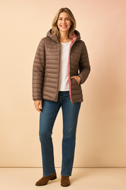 Taupe puffer jacket with pink lining, paired with a plain white T-shirt, straight-leg blue jeans, and brown suede ankle boots.