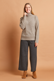 Taupe turtleneck sweater with textured geometric diamond knit pattern, ribbed cuffs, and hem.