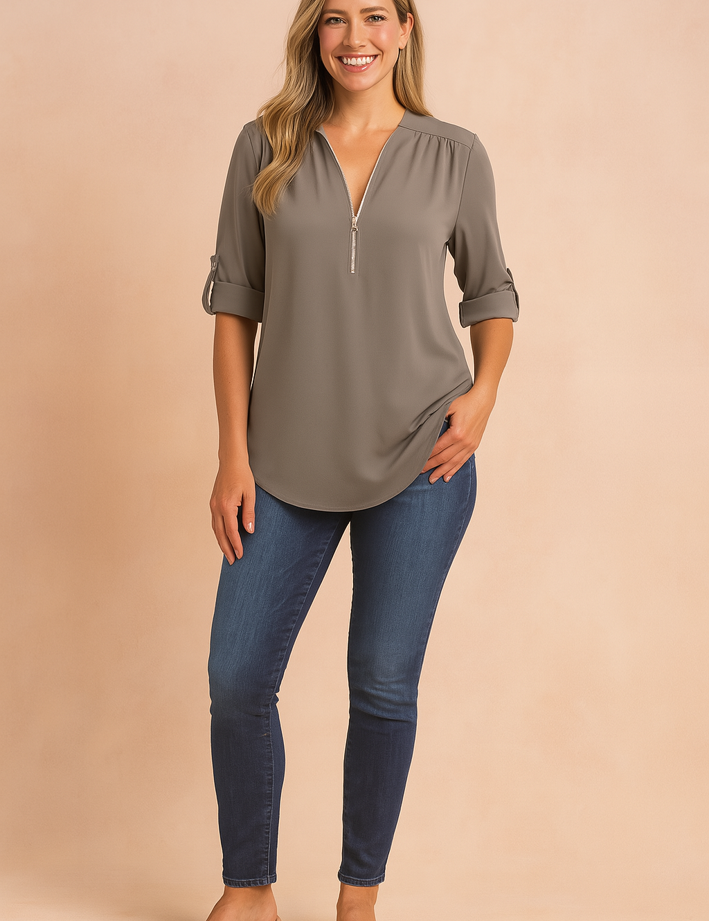 Taupe-gray zip-front blouse with roll-tab sleeves, paired with dark wash skinny jeans and beige block-heel sandals for a polished everyday outfit.