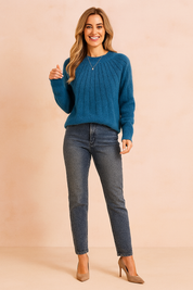Teal ribbed crew-neck sweater paired with dark wash slim-fit jeans and beige pointed-toe heels, accessorized with a delicate silver pendant necklace.