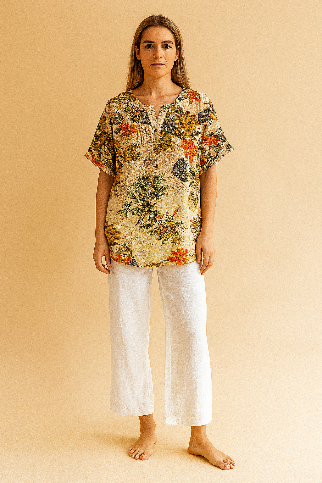 tropical floral tunic top featuring a cream background with vibrant leaf and blossom prints, styled with white linen pants—ideal for casual summer fashion.