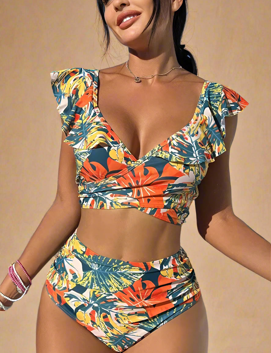 Two-piece tropical print bikini featuring a high-waisted bottom and a deep V ruffle-shoulder top, designed in a vivid mix of orange, yellow, green, and navy botanical patterns for a bold summer-ready look.