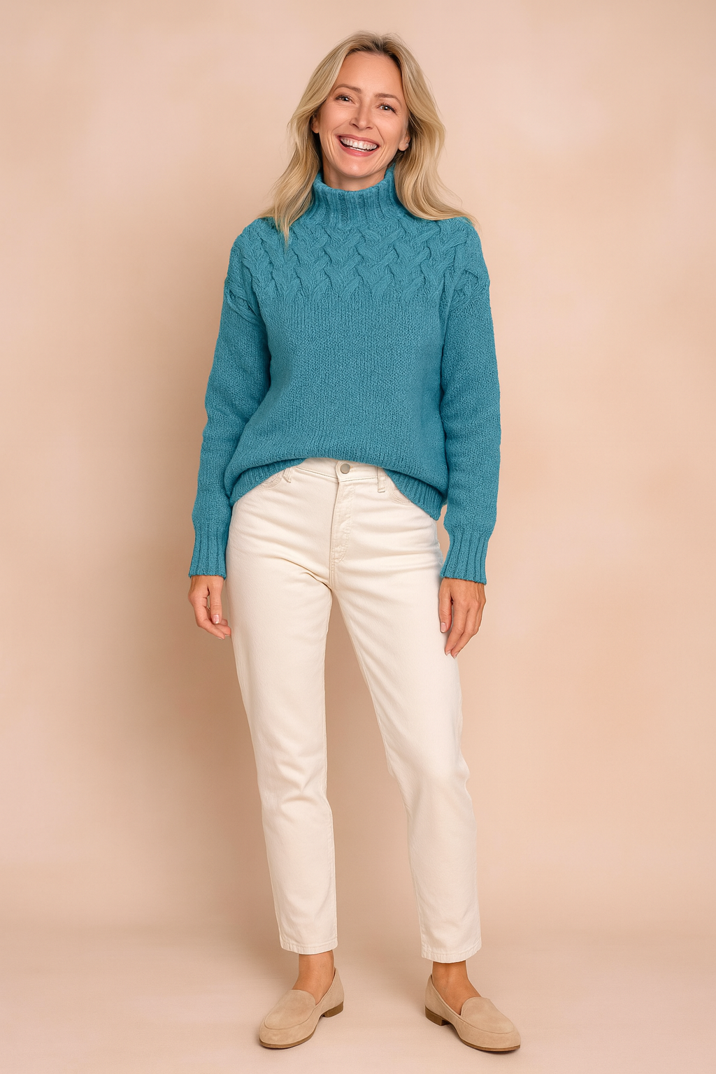 Turquoise cable-knit high-neck sweater with intricate braided pattern on the upper bodice, paired with off-white straight-leg pants and beige suede loafers.