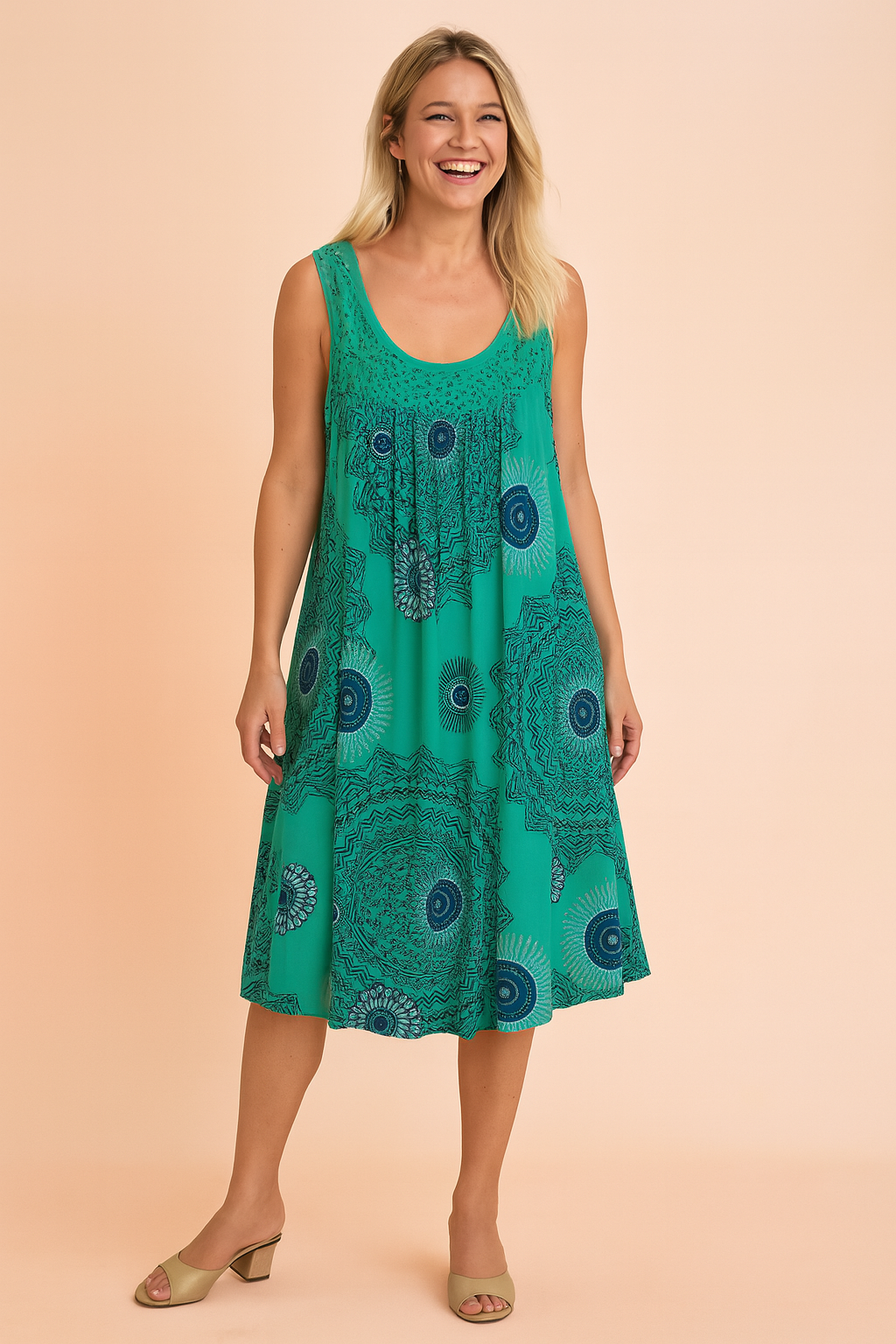 Sleeveless A-line turquoise sundress featuring intricate navy mandala print, delicate pleated detailing at the bust, and a relaxed knee-length silhouette with a flowing hemline.