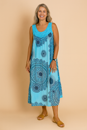 Flowy turquoise sleeveless sundress featuring bold navy mandala prints and a relaxed A-line silhouette, designed for a breezy, bohemian summer look.