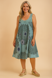 Sleeveless turquoise sundress with intricate dark blue and white mandala patterns, flowing A-line cut, and subtle crochet detailing around the scoop neckline.