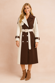 Two-tone trench coat with a belted waist, wide lapel collar, double-breasted button design, and adjustable sleeve straps, combining cream and deep brown panels for a bold, modern contrast.
