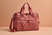 Dusty rose nylon travel tote with dual zipper closure, thick matching top handles, wide detachable strap, and reinforced buckle details.