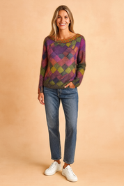 Colorful diamond-pattern knit sweater with soft gradient shades of purple, pink, green, yellow, and orange, paired with relaxed-fit blue jeans and white sneakers.