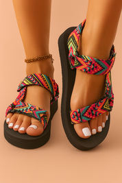  Women's colorful geometric-patterned platform sandals with adjustable tribal-style fabric straps and thick black soles, ideal for casual summer wear.