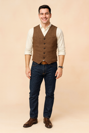 Brown vintage button-up vest with a textured herringbone fabric, paired with a cream shirt and dark blue jeans, styled with a brown belt and leather shoes for a classic casual look.