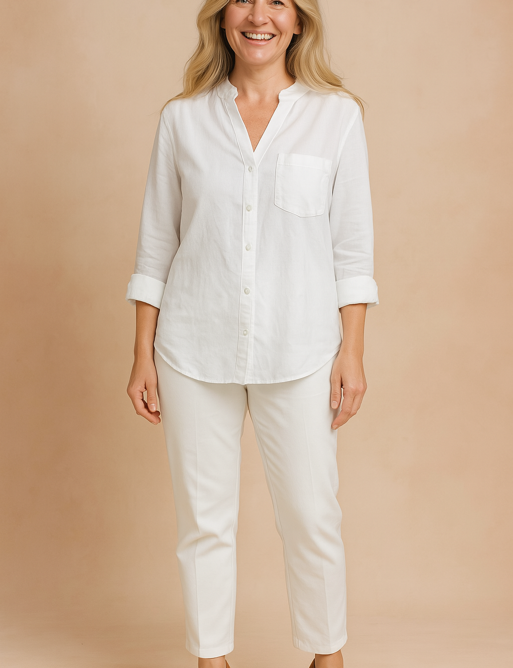Crisp white long-sleeve linen blouse with rolled cuffs, front chest pocket, and button-down design, styled with tailored white pants and brown block-heel shoes.