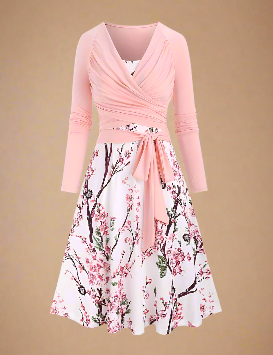 White sundress with detailed pink cherry blossom branches and subtle green foliage print, styled in a classic A-line silhouette with spaghetti straps and a flowy dress.