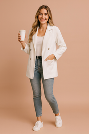 White corduroy double-breasted blazer with brown buttons, tailored lapel collar, long sleeves, and a relaxed fit design, paired with denim jeans for a chic casual look.
