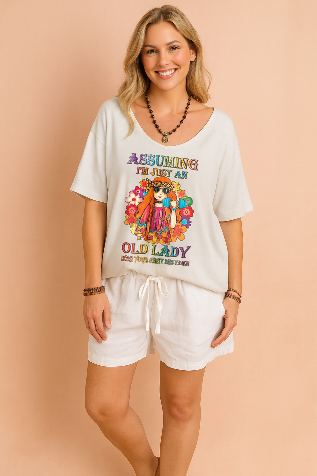 Loose-fit white T-shirt with colorful hippie-style graphic and bold text, paired with white drawstring shorts, perfect for a relaxed and playful summer look.