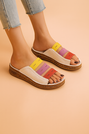 Women's open-toe slide sandals with multi-colored leather straps in yellow, lavender, and red, paired with a white leather upper and thick cork-textured platform sole.