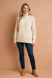 White ribbed turtleneck sweater with long sleeves, paired with dark slim-fit jeans and beige suede ankle boots.