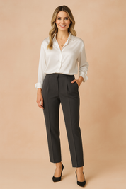 White satin long-sleeve button-down blouse with a relaxed fit and structured cuffs, tucked into tailored charcoal trousers and paired with black heels.