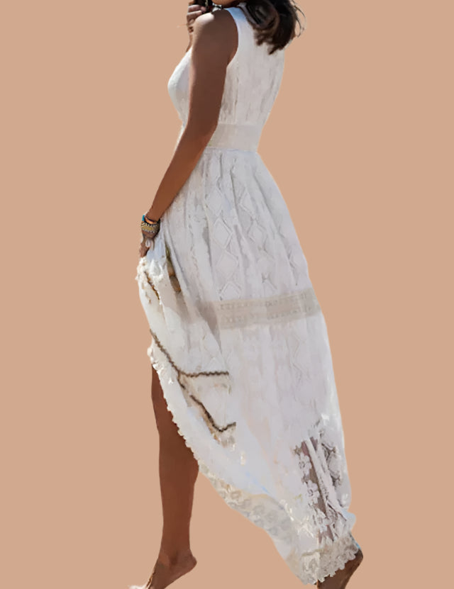 Koronkowa sukienka boho maxi w kolorze ecru z wyraźnym wzorem rombów i kwiatowym haftem, dopasowana w talii, z wysokim rozcięciem z przodu, ozdobnym obszyciem przy dole oraz efektownym tyłem podkreślającym lekkość i strukturę tkaniny.