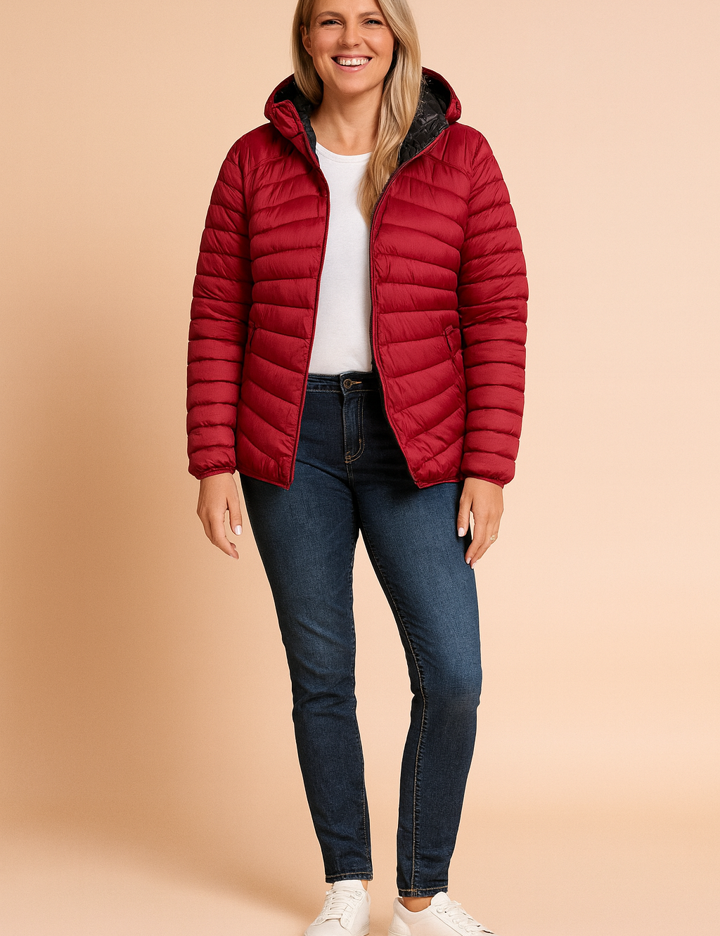 Lightweight quilted puffer jacket in deep wine red with horizontal stitching, front zipper closure, side zip pockets, and black inner lining, styled over a plain white top with dark blue slim-fit jeans and white sneakers.