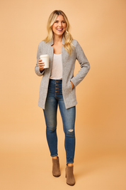Women’s long open-front grey herringbone knit cardigan paired with a white top and high-waisted blue button-up skinny jeans, designed for casual comfort and effortless style.