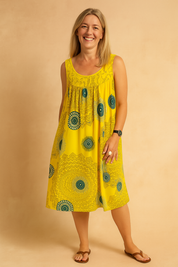 Sleeveless yellow swing dress with emerald green mandala print, featuring a gathered bust detail and relaxed A-line silhouette, perfect for casual summer styling.